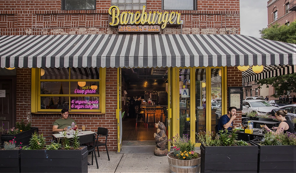 Bareburger restaurant front on 31st Ave Astoria New York with people enjoying delicious sustainable meals