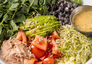 Bareburger's Cali Bowl, packed with fresh greens, grilled chicken, avocado, and a vibrant medley of veggies, topped with a zesty dressing for a healthy, flavor-packed meal